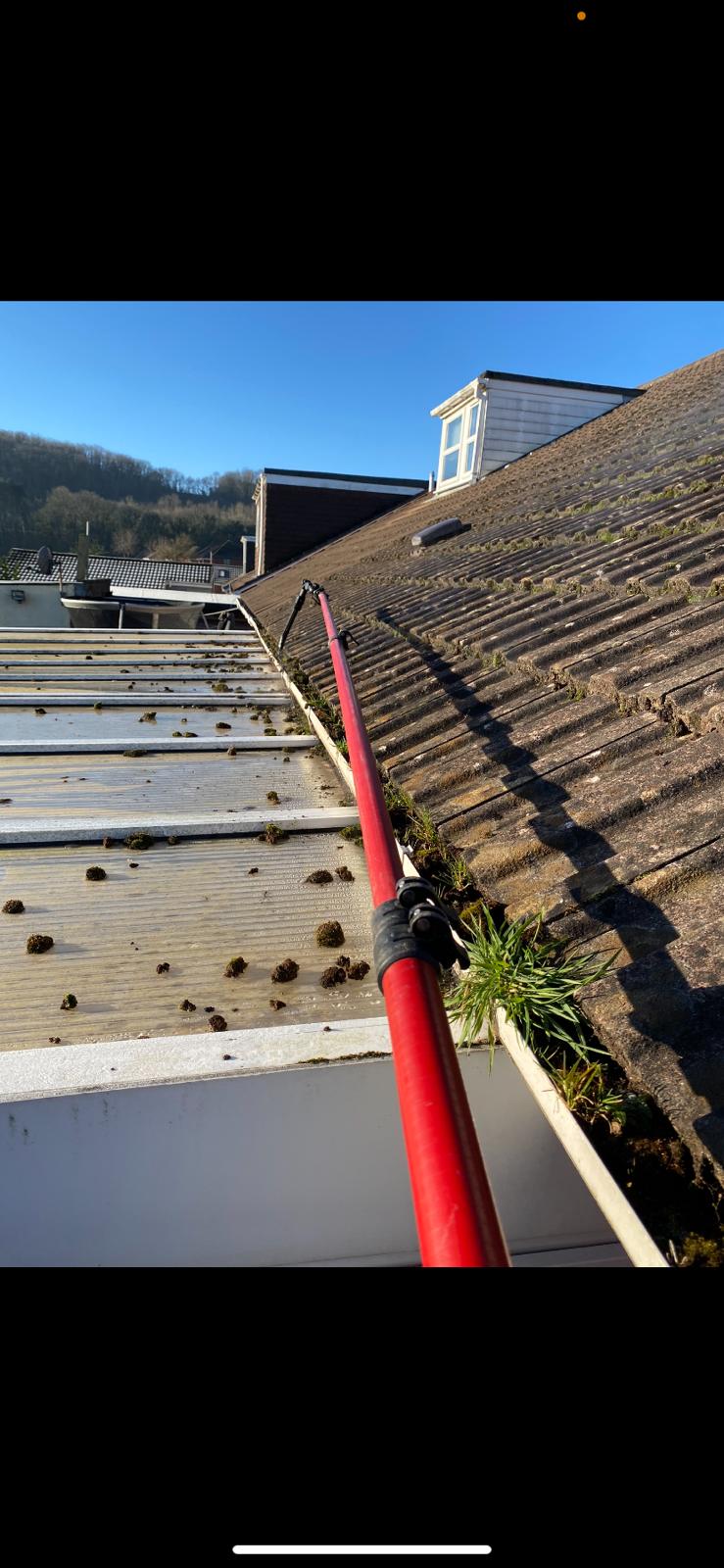 A photo of gutters being cleared and cleaned