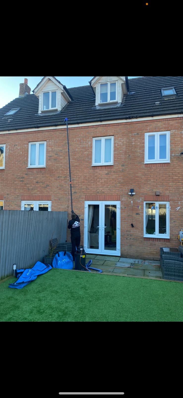 A 3 story window being cleaned from the ground floor.